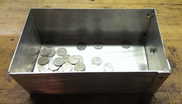 Møntskuffe, set oppefra. Det er lidt penge i kassen. Det giver en dejlig "klonk" lyd når en mønt lander.